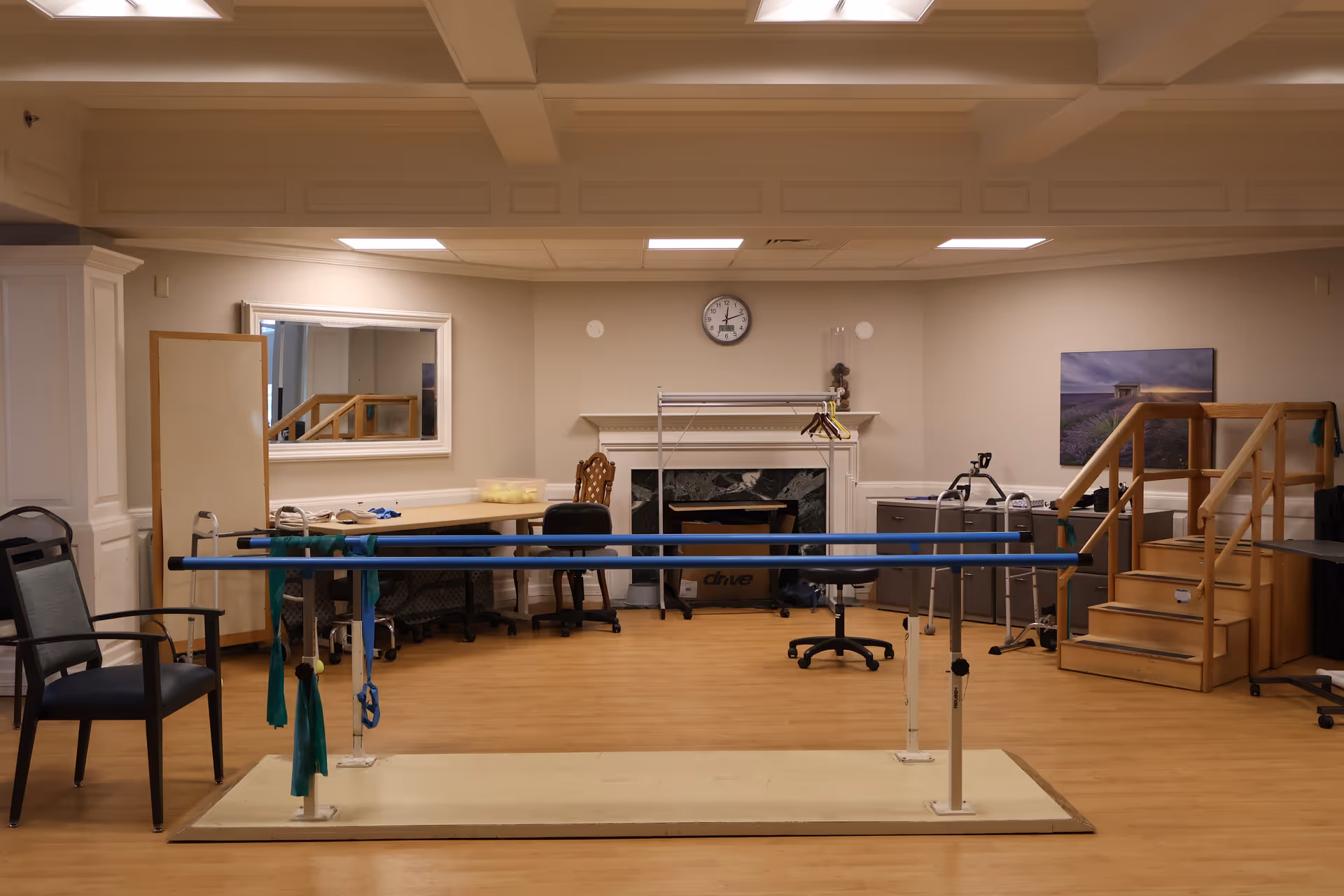 Interior rehabilitation room in a senior facility with parallel bars and stair setup.