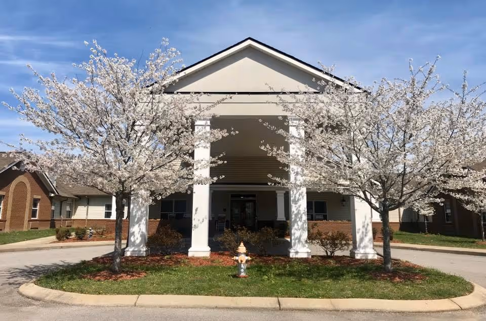 Grace Manor Assisted Living front entrance with white columns and blossoming trees