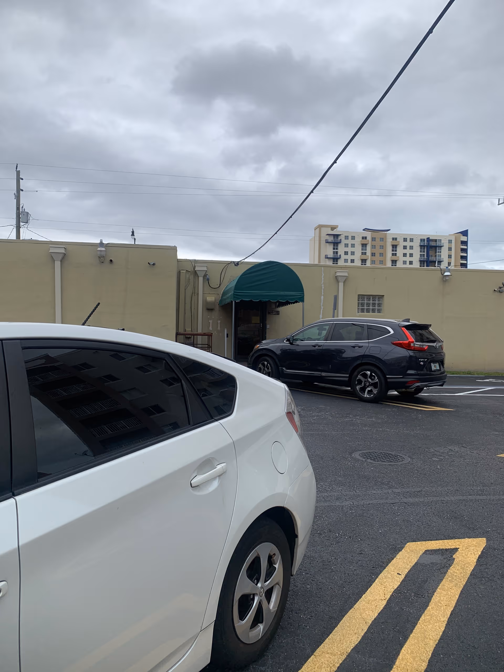 Exterior view of Fatima Home Care building with parked cars and a green awning.