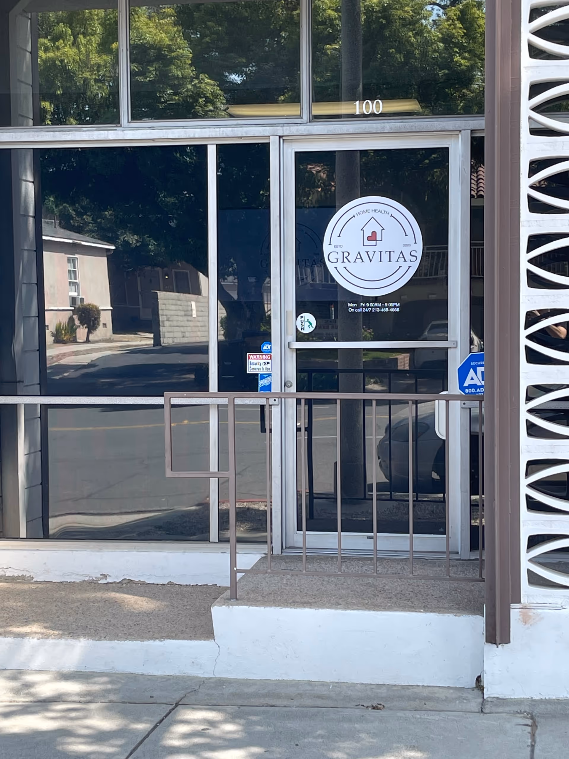Glass storefront entrance with Gravitas Home Health Care logo and ramp to the door.
