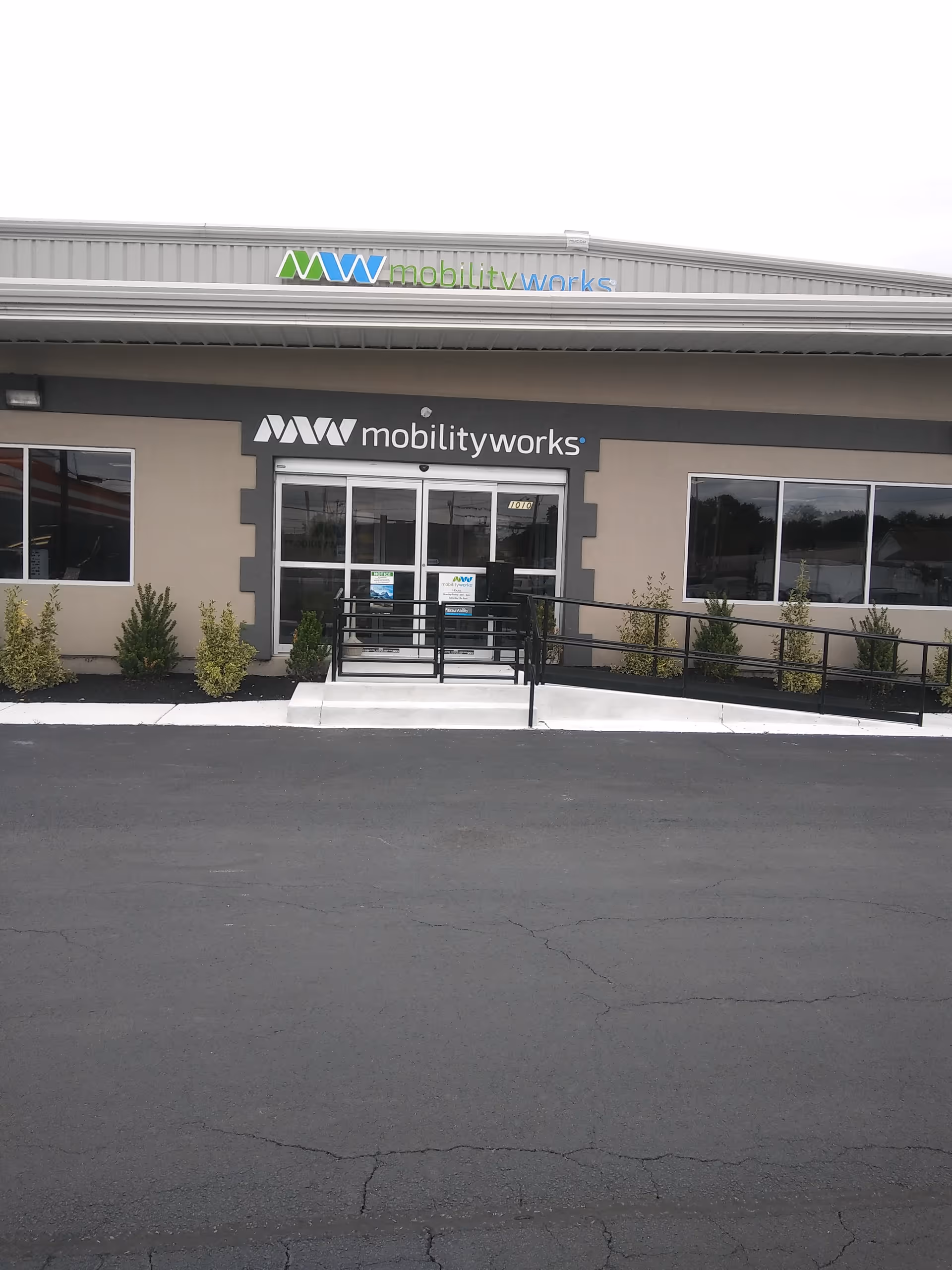 Exterior view of MobilityWorks storefront with entrance, ramp, and shrubs.