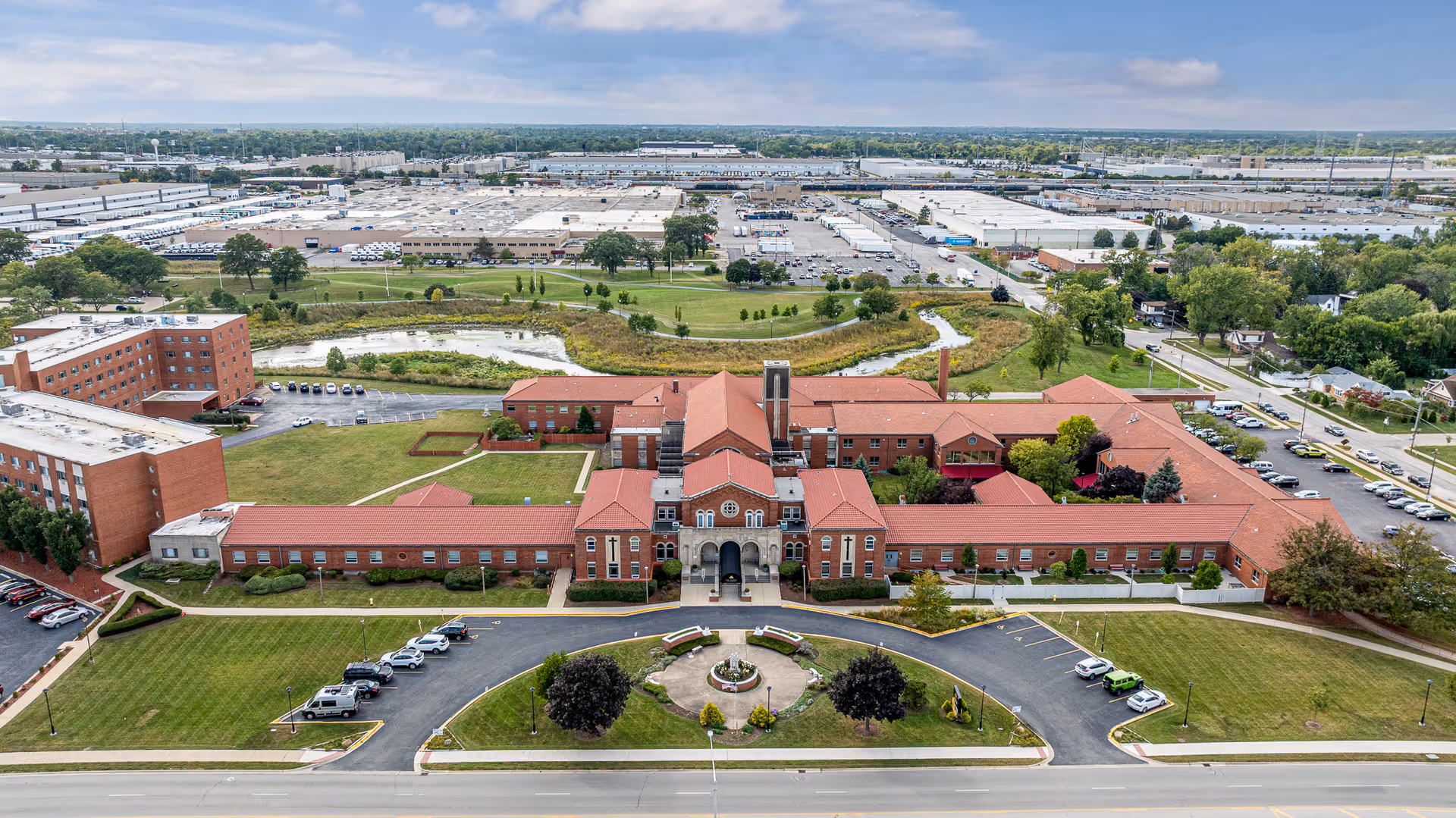 Aerial view of Citadel at Casa Scalabrini campus with red-roofed buildings and circular driveway.