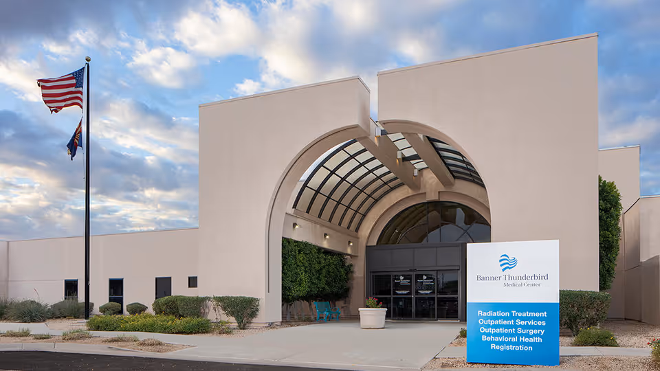 Front exterior of Banner Thunderbird Medical Center with arched entrance and flagpole.