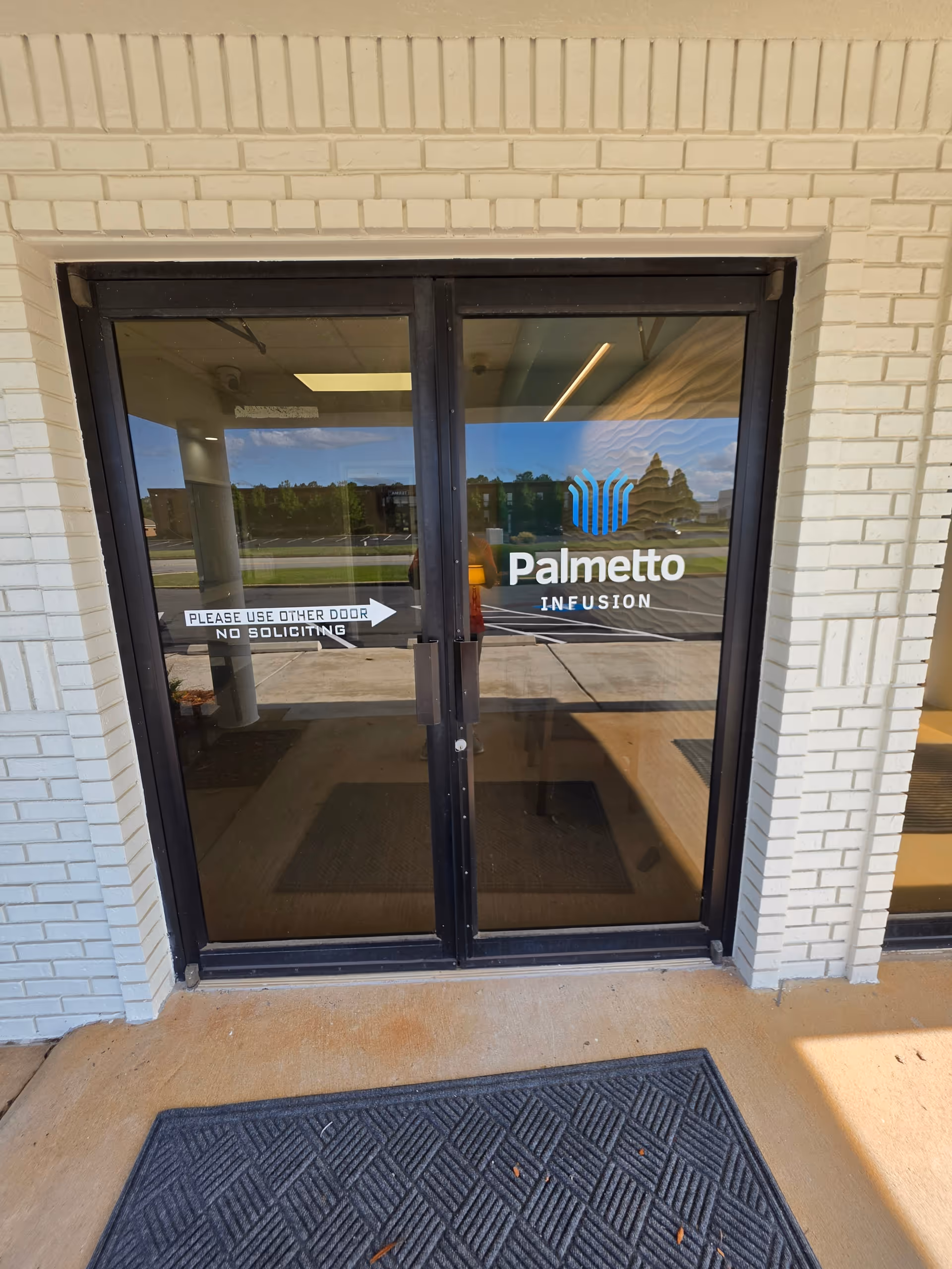 Glass entrance doors with Palmetto Infusion logo, brick exterior, and a 'Please use other door' sign.