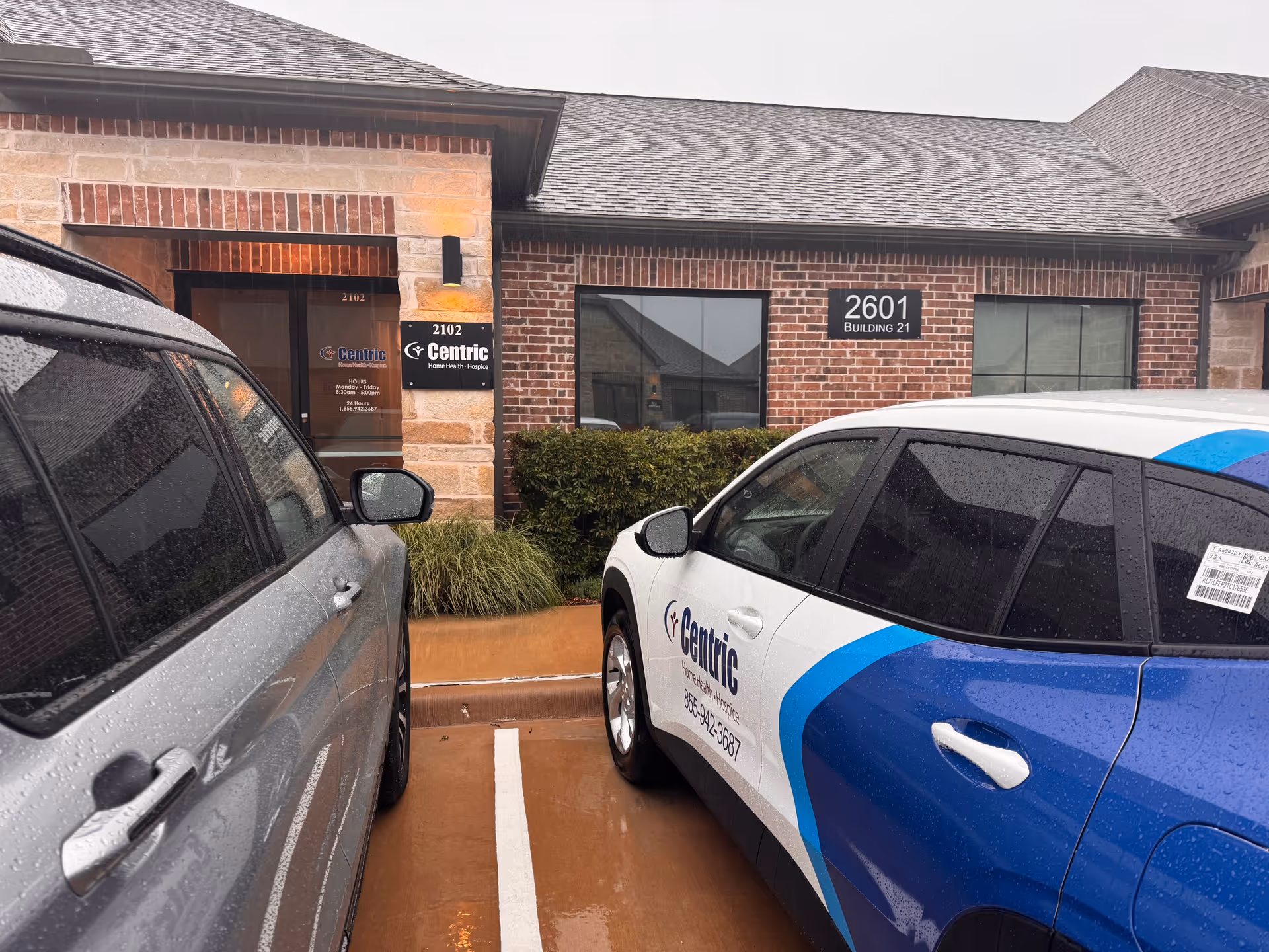 Brick facility exterior with Centric signage and cars parked in front.
