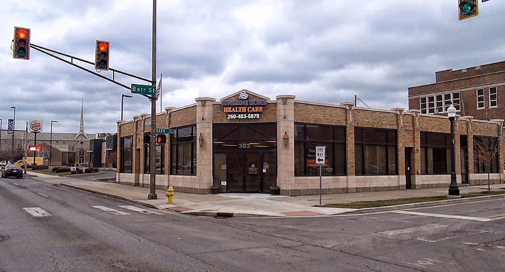 Corner street view of Sunshine Home Care Services building with large storefront windows.