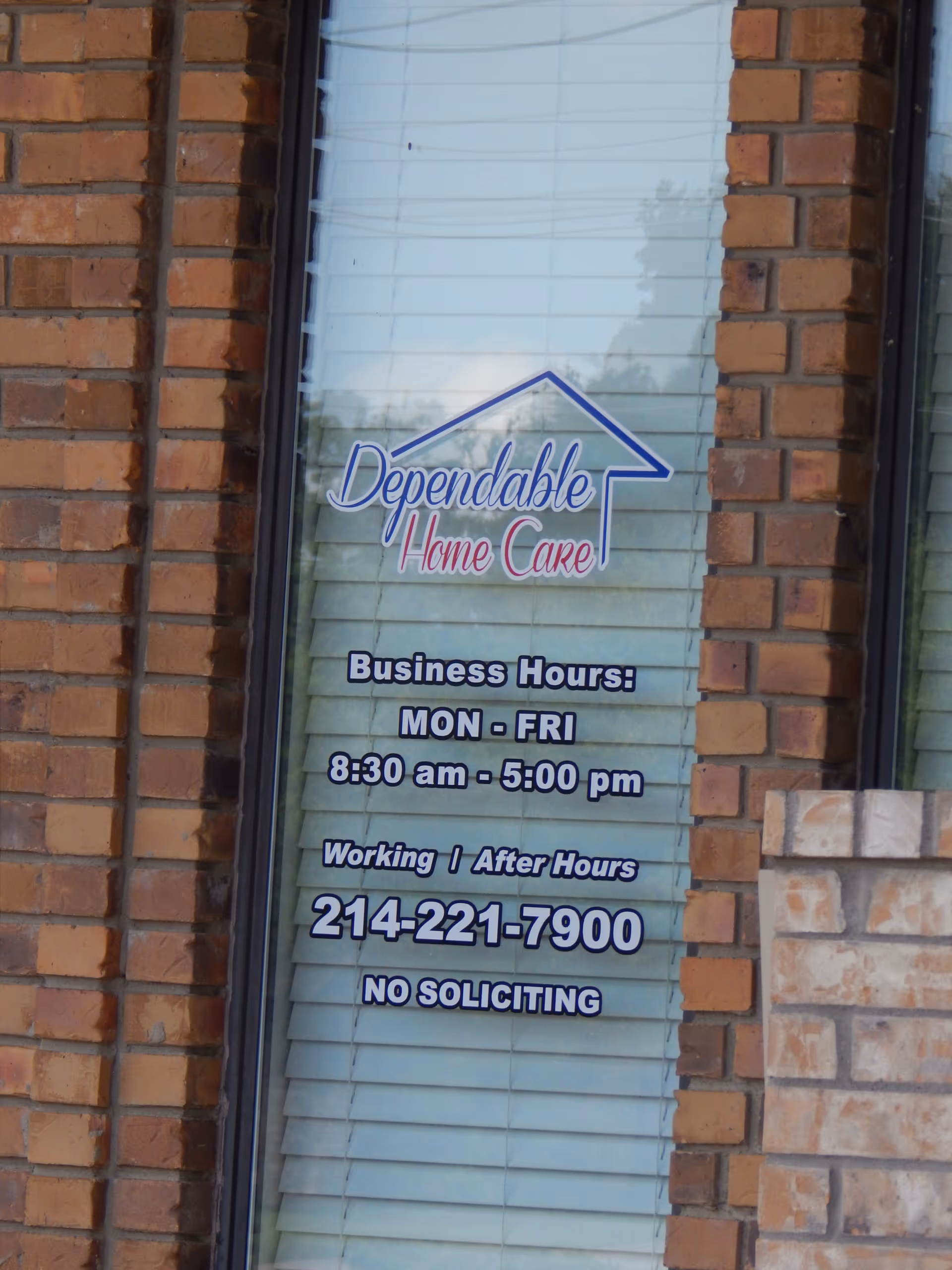 Brick exterior with glass window displaying Dependable Home Care logo and business hours.