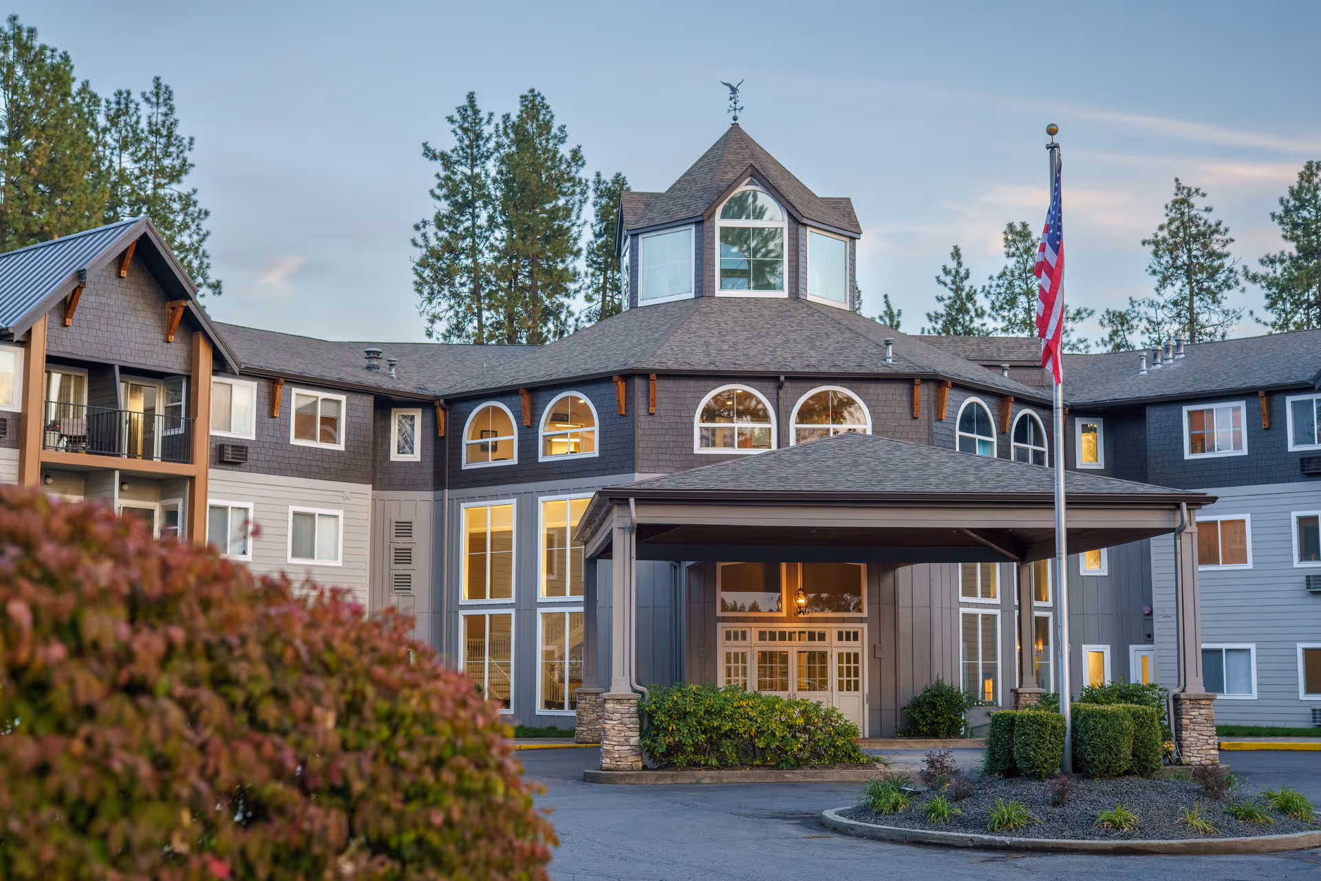 Exterior view of North Star Assisted and Senior Living building with entrance canopy and flagpole.