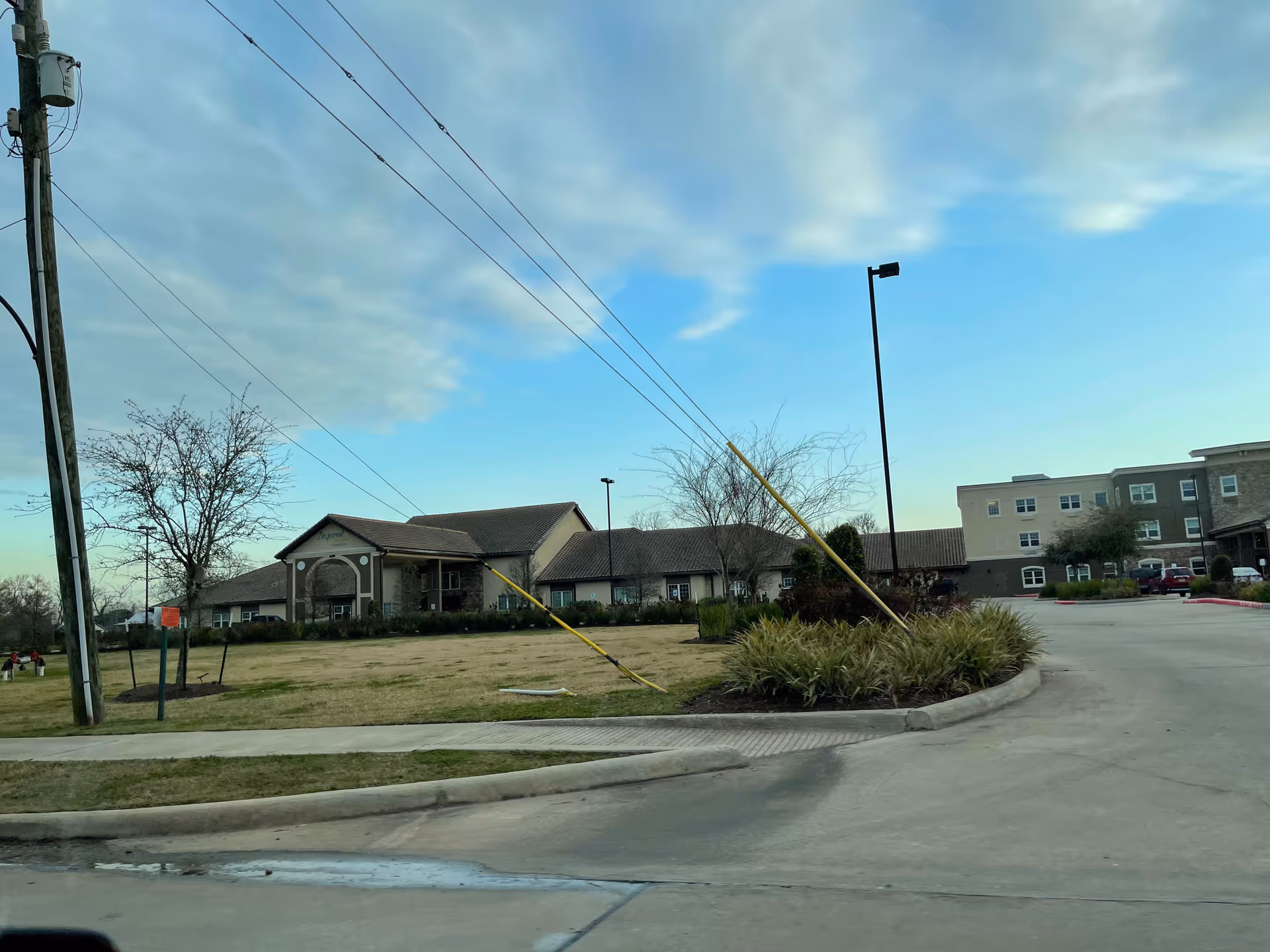Exterior view of Laurel Glen at Sugar Land showing entrance, parking, and landscaped roundabout.