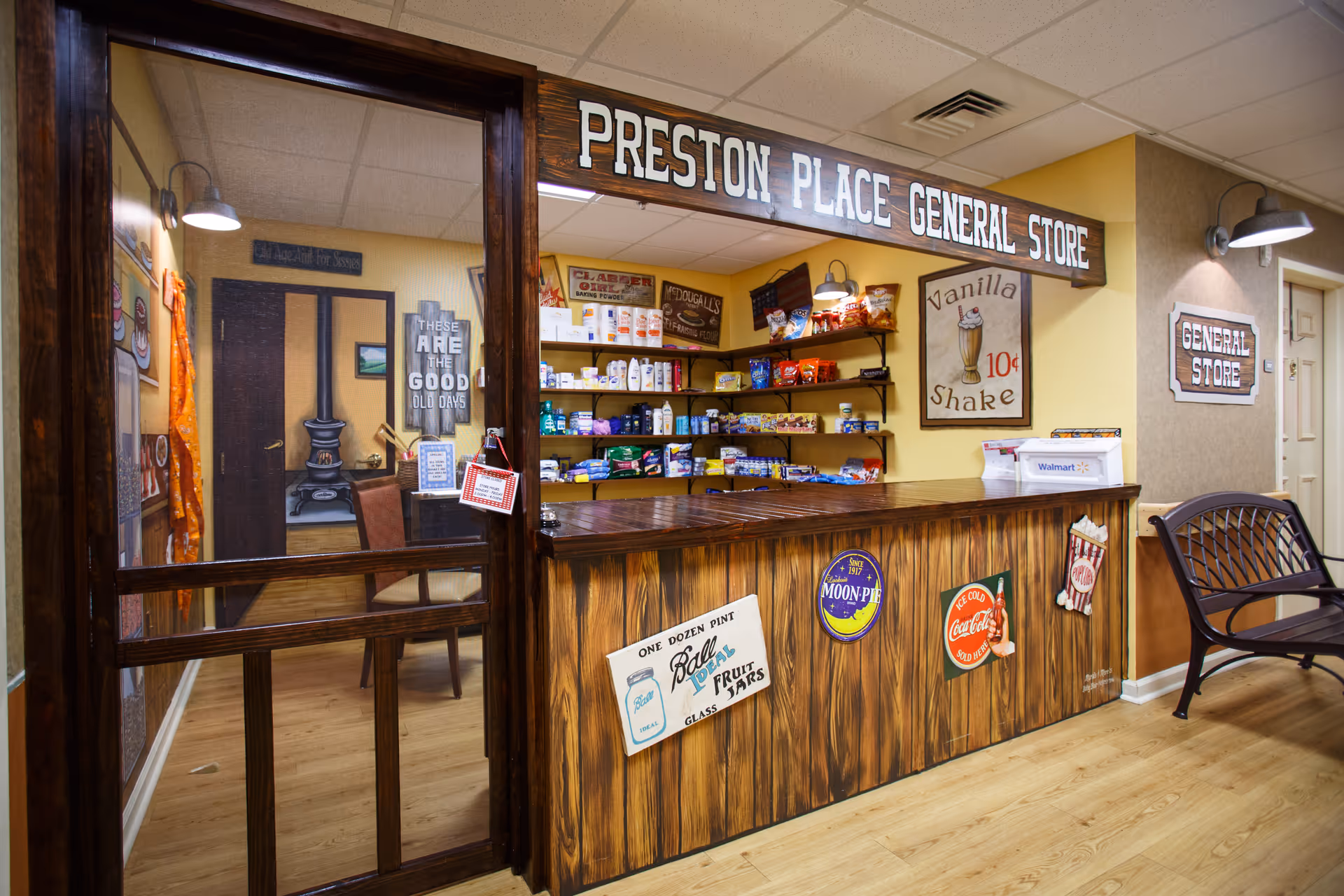 Interior view of a small decorated 'Preston Place General Store' counter and shelves stocked with snacks and goods.