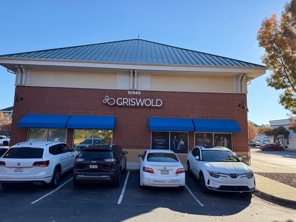 Griswold building front with blue awnings and parked cars outside