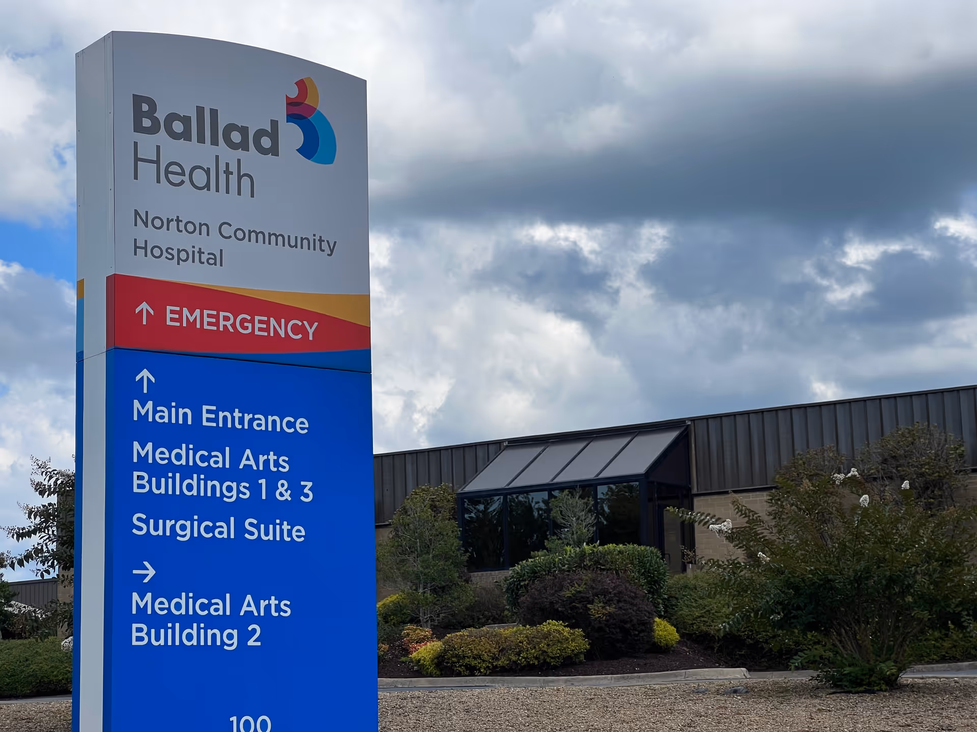 Ballad Health sign in front of a hospital building with landscaping.