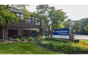 Exterior view of The Pearl of Rolling Meadows with landscaped entry and sign.