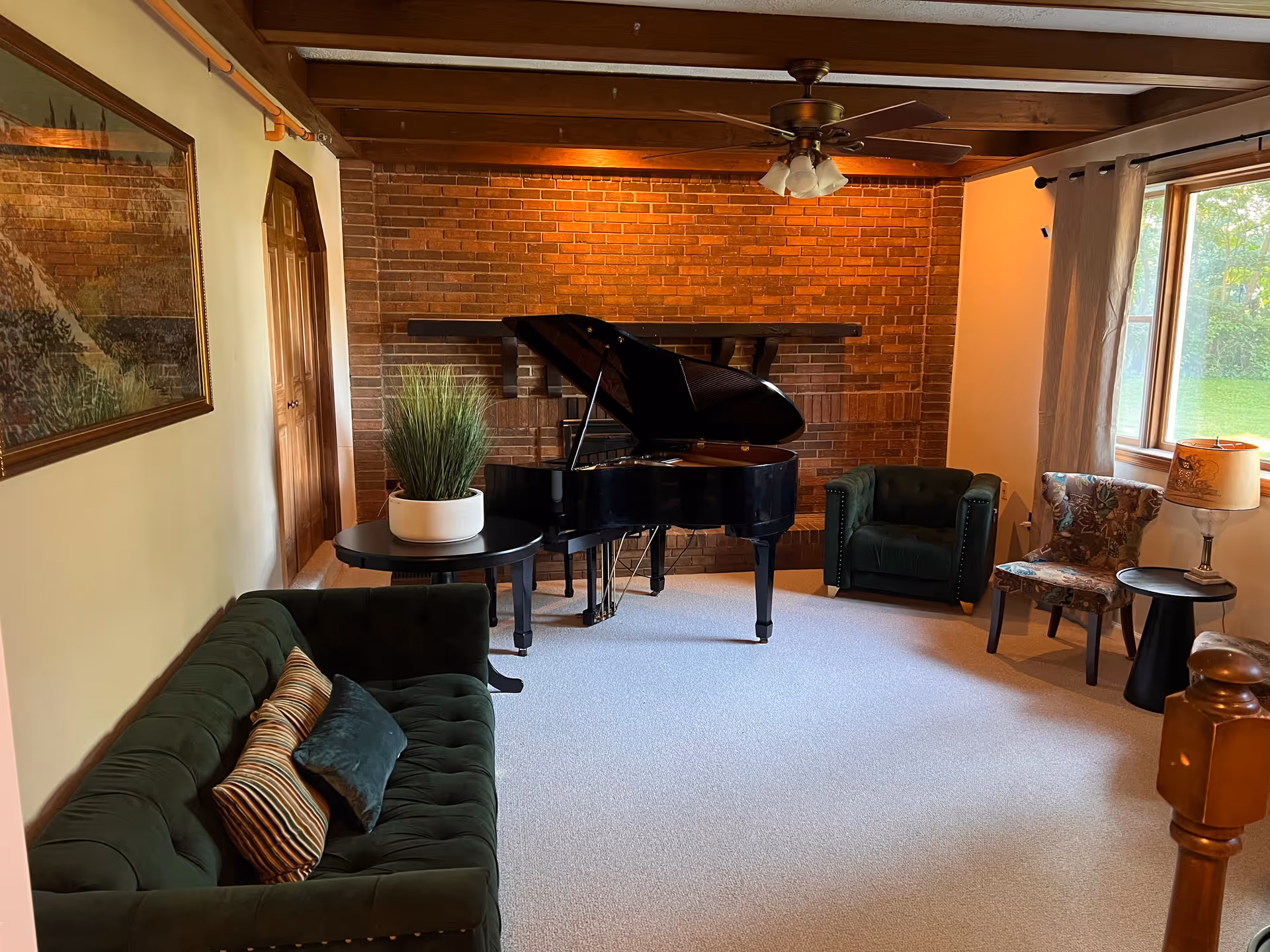 Cozy living room with a grand piano, brick fireplace, and multiple seating areas.