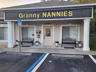Front of Granny NANNIES Senior Care entrance with benches and potted plants.