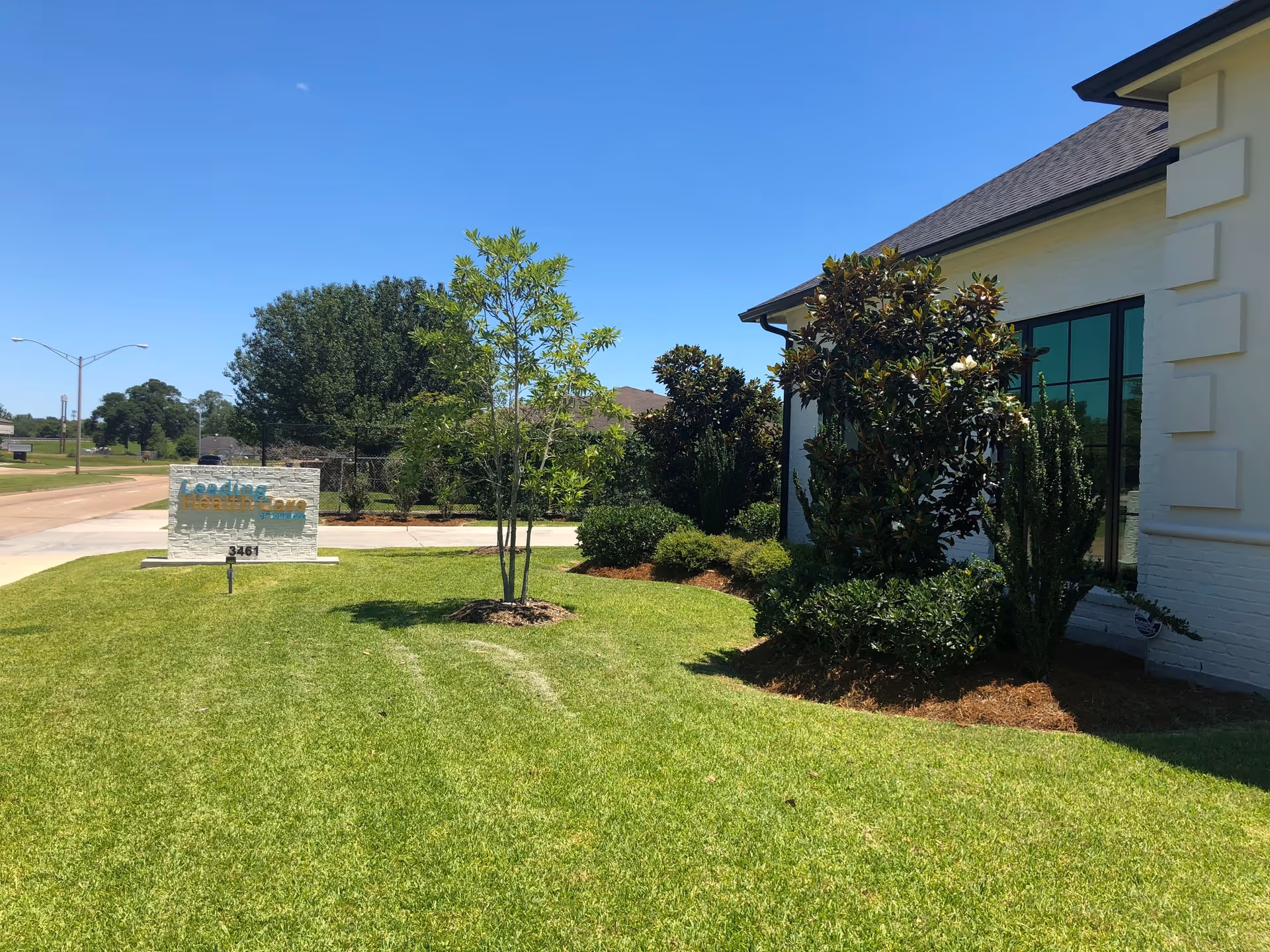 Exterior view of Leading Home Care Lake Charles building with sign and lawn.