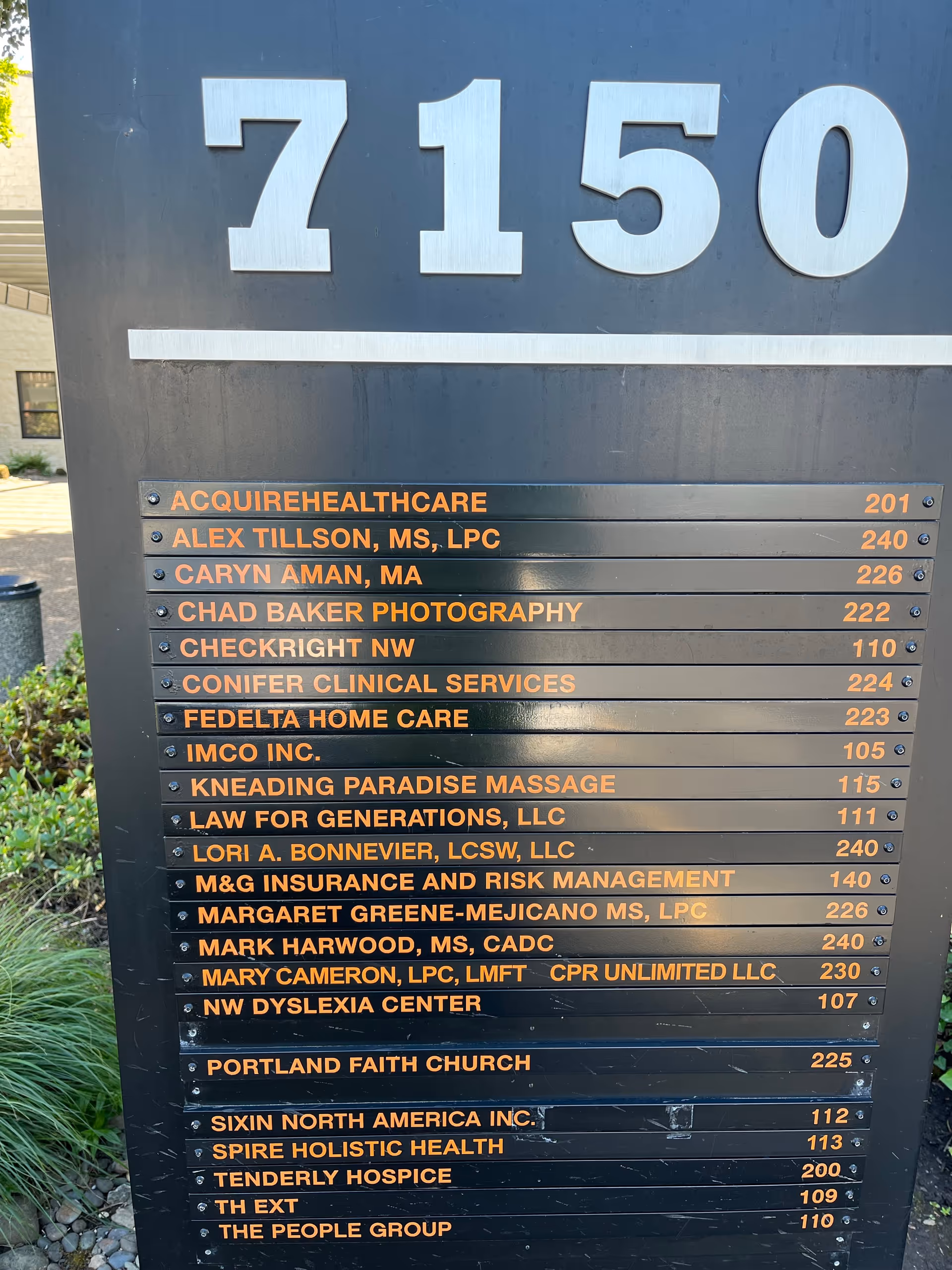Outdoor building signboard listing tenants and address 7150.