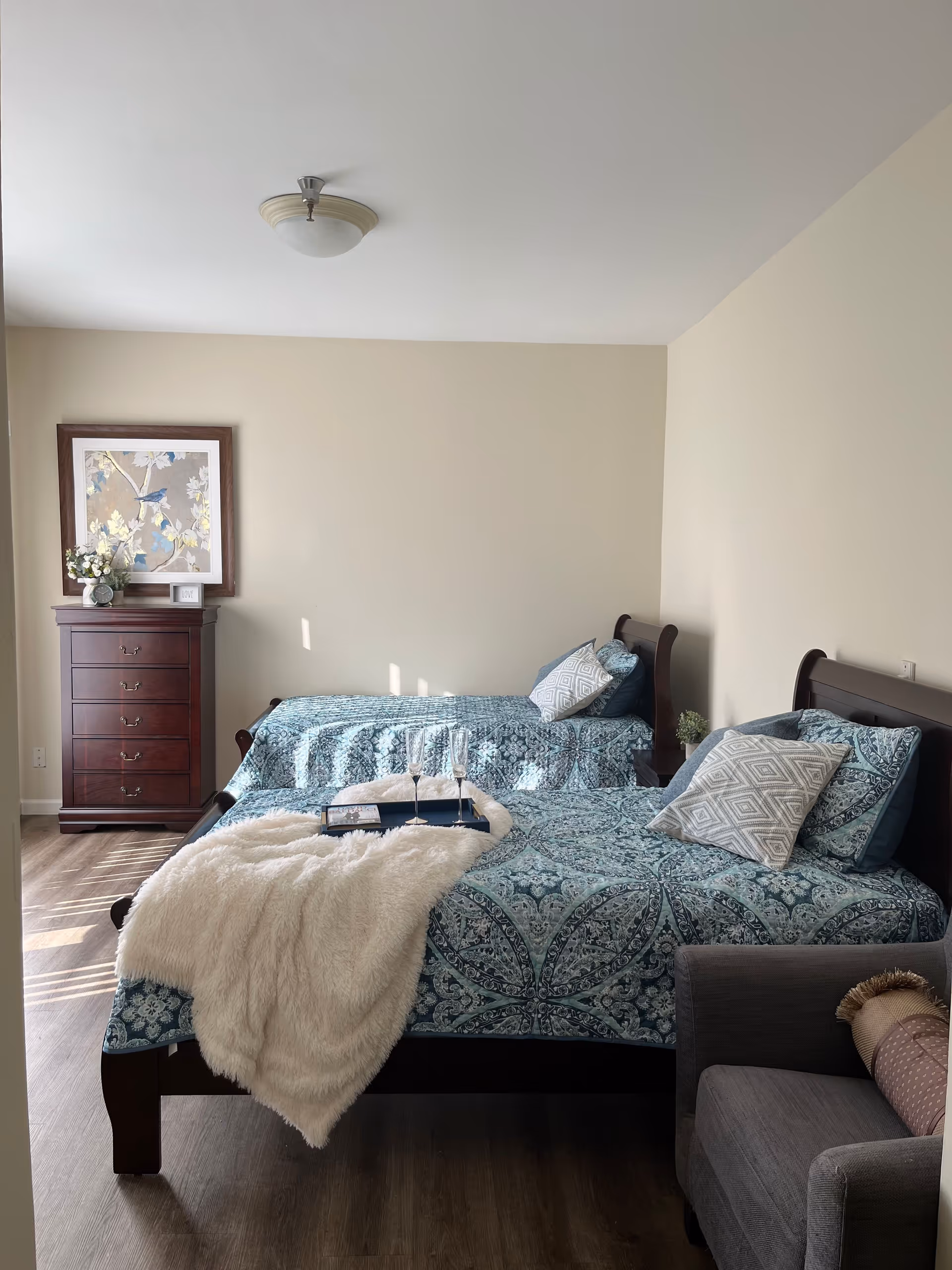 Two twin beds with blue patterned bedding in a bright, neatly furnished bedroom.