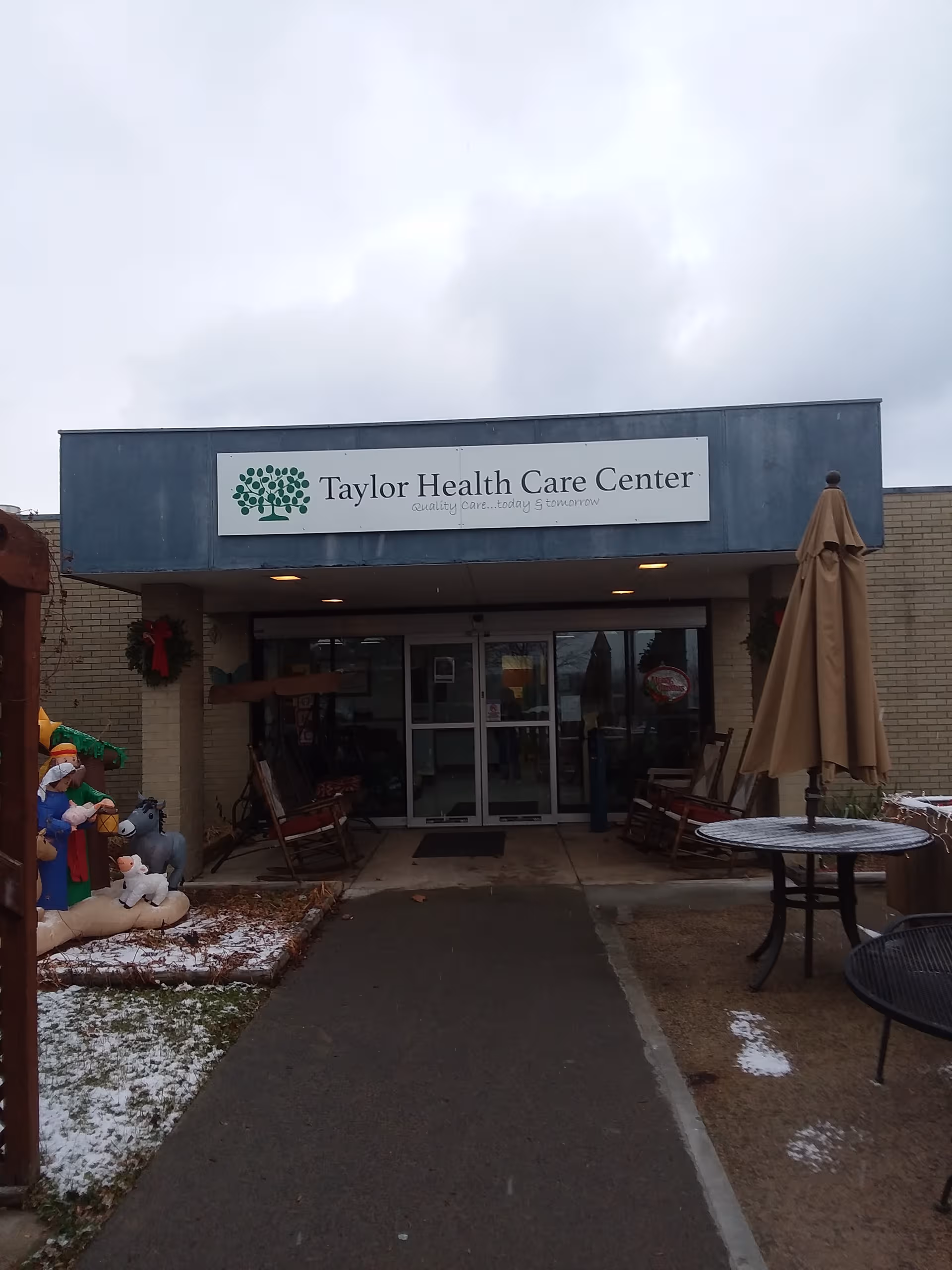 Exterior view of Taylor Health Care Center entrance with outdoor seating and walkway