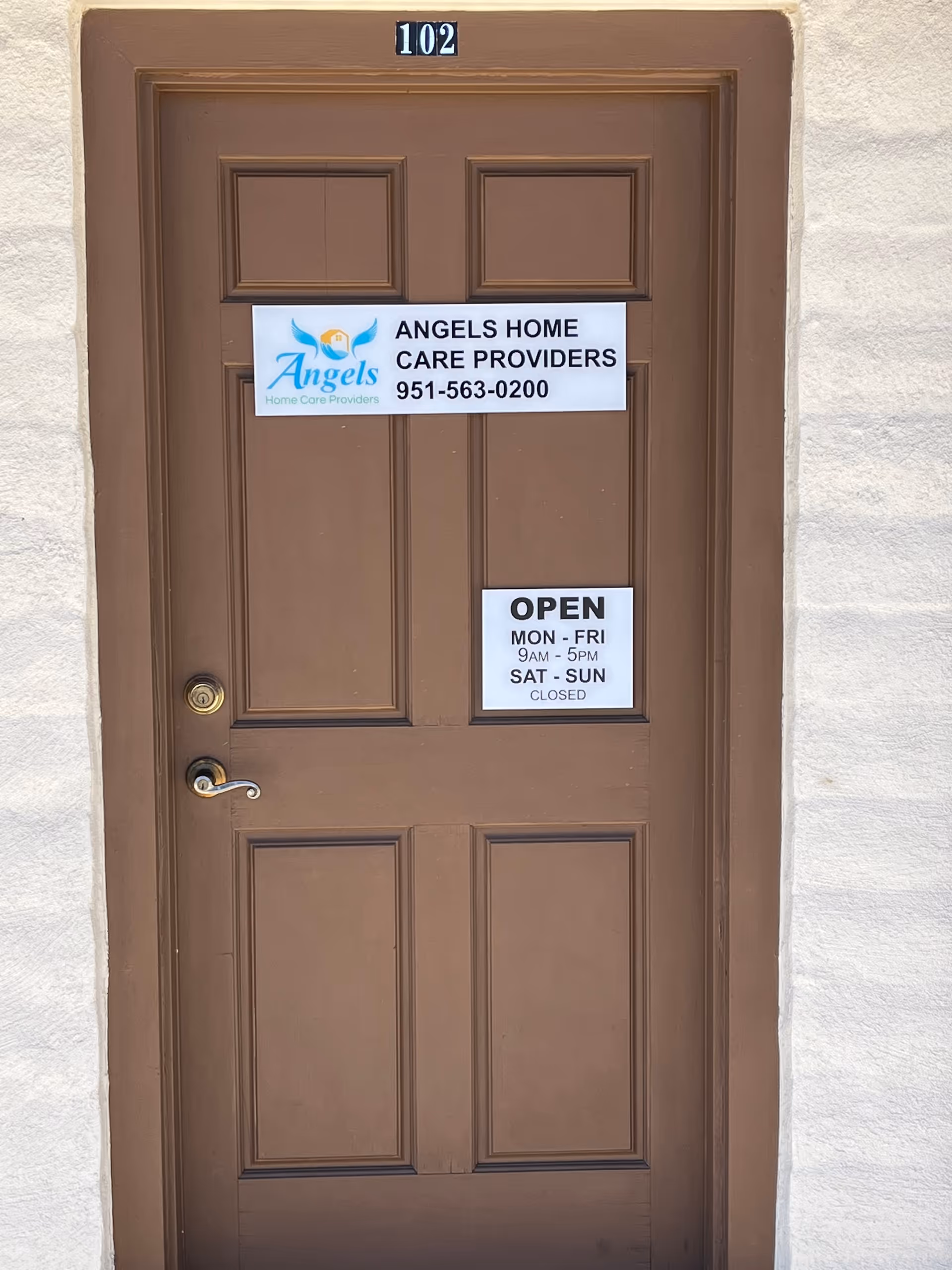 Brown exterior door with open hours sign and Angels Home Care Providers signage.