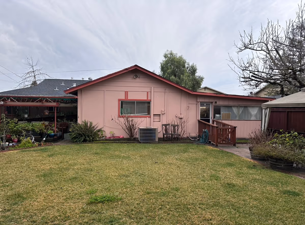 Pink, single-story facility with a small deck and lawn in the front yard.