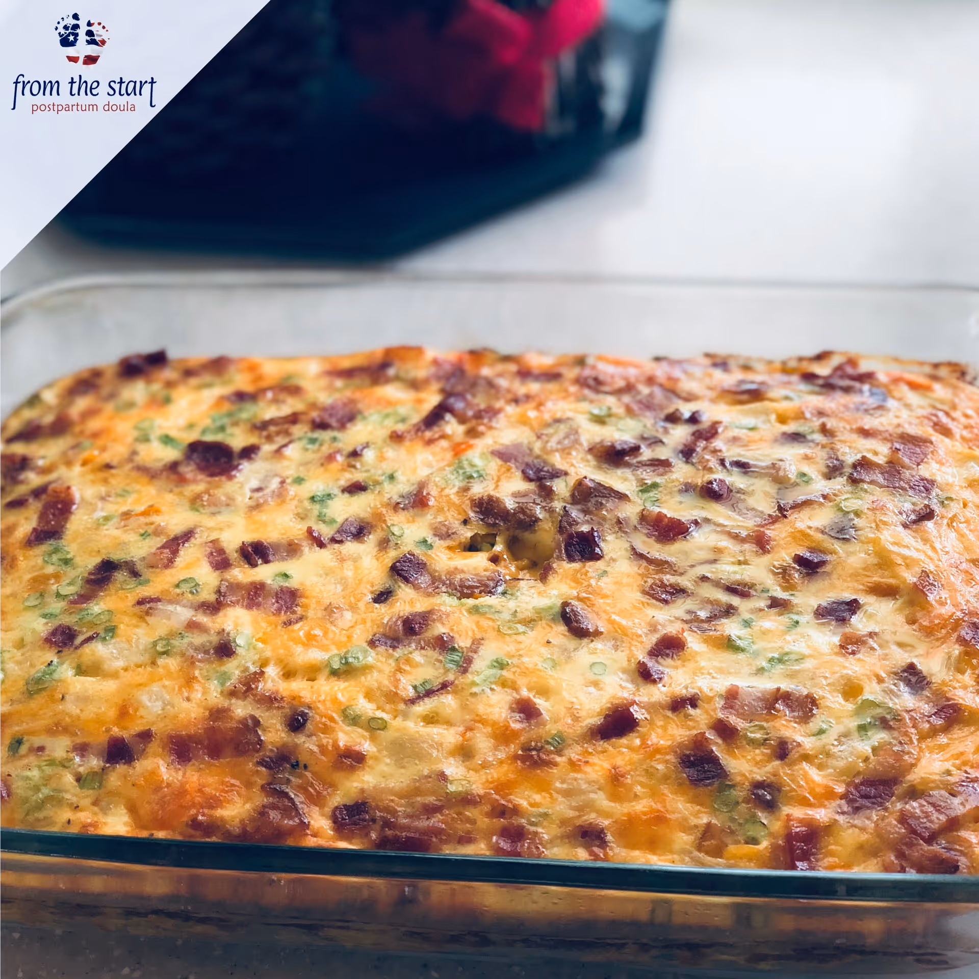 Cheesy casserole in a glass baking dish on kitchen counter, with from start logo in corner.