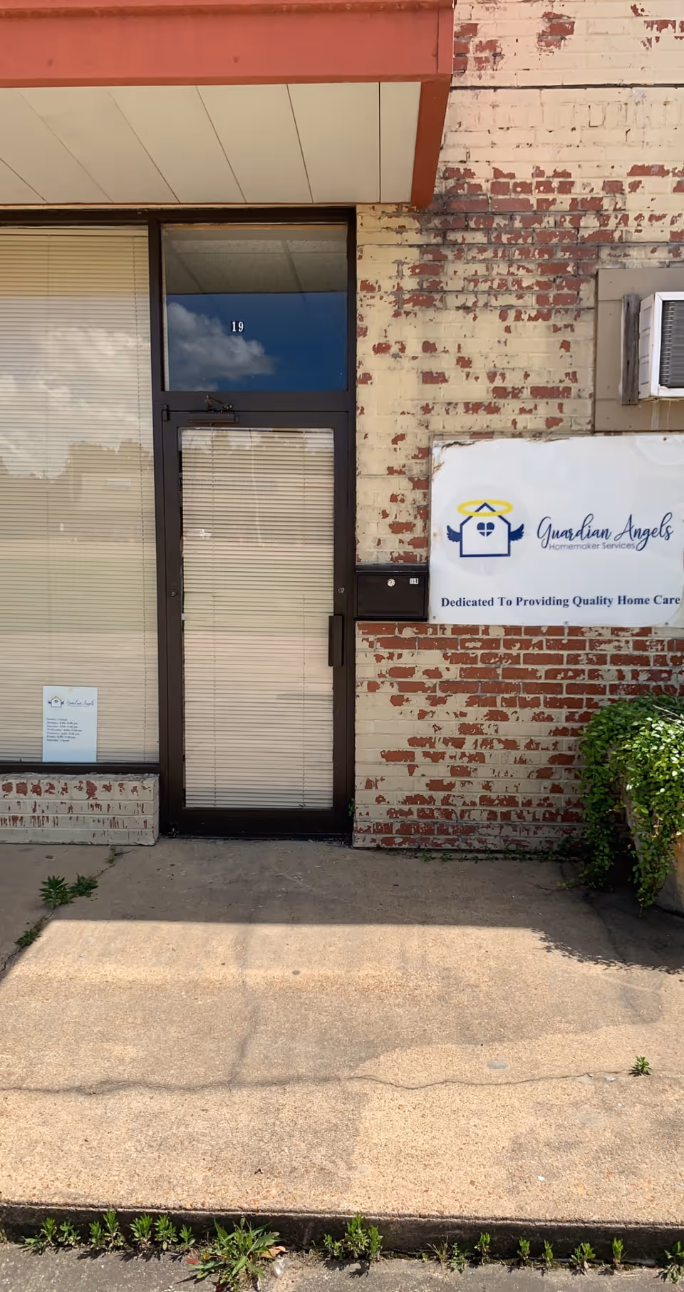 Front entrance of a brick building with door and Guardian Angels Homemaker Services sign.