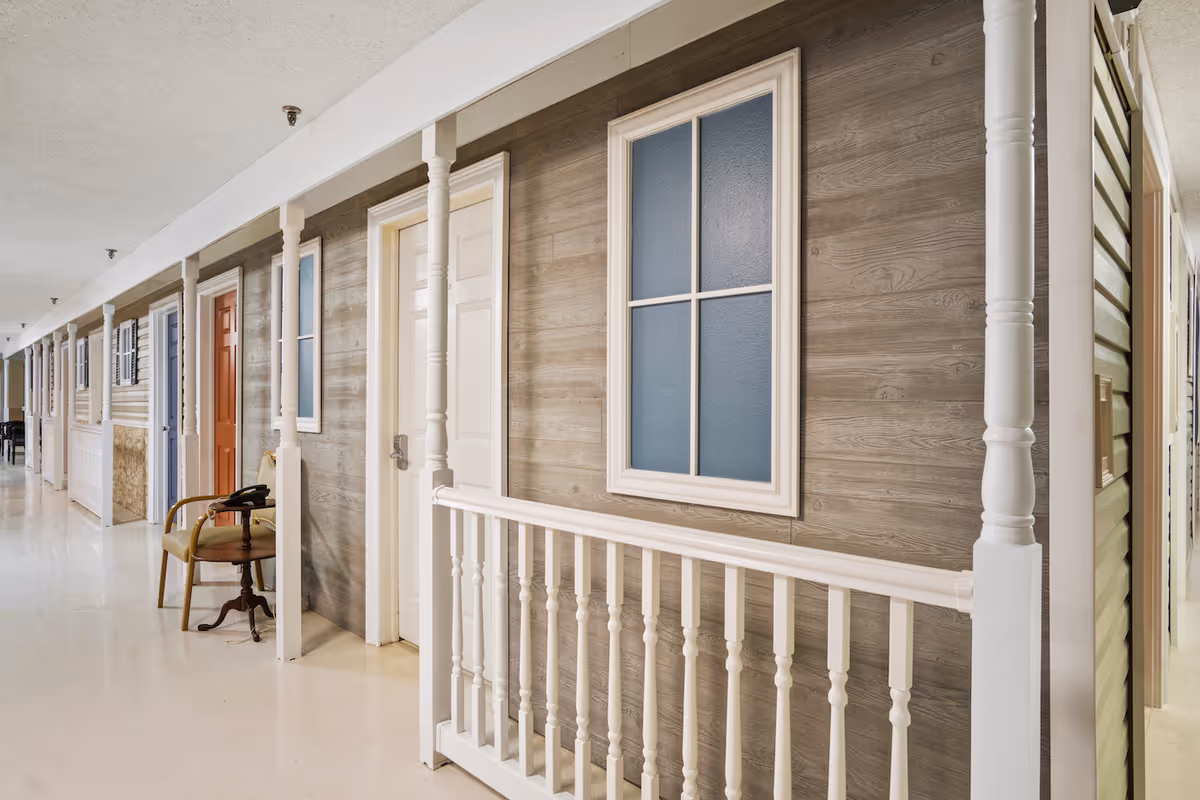 A long interior hallway of Cedar Falls Health Care Center with several doors and railings.