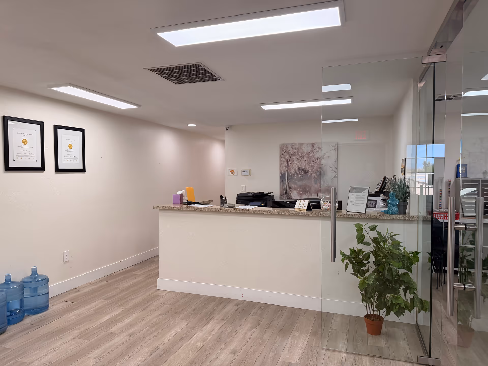 Reception desk in a modern Billet Home Health - Peoria lobby with glass walls.