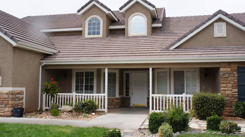 Exterior view of a beige senior living home with a covered porch.