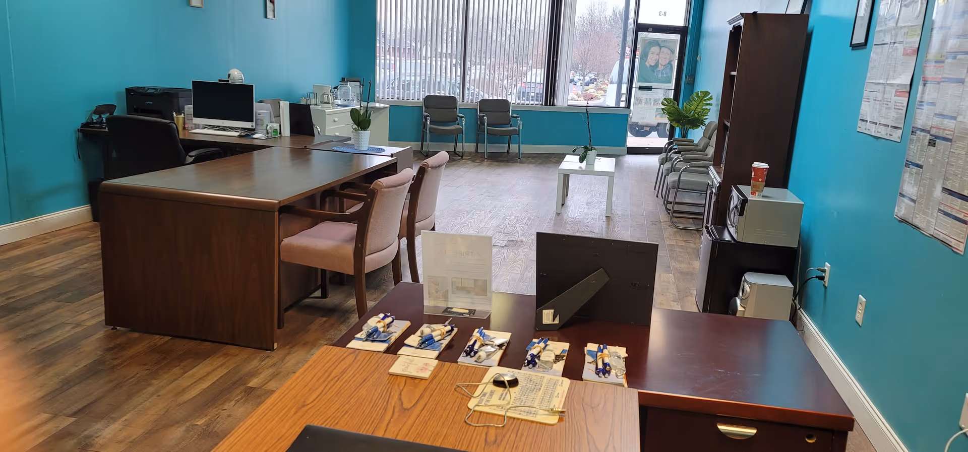 Interior reception area of a senior care facility with teal walls and desks.