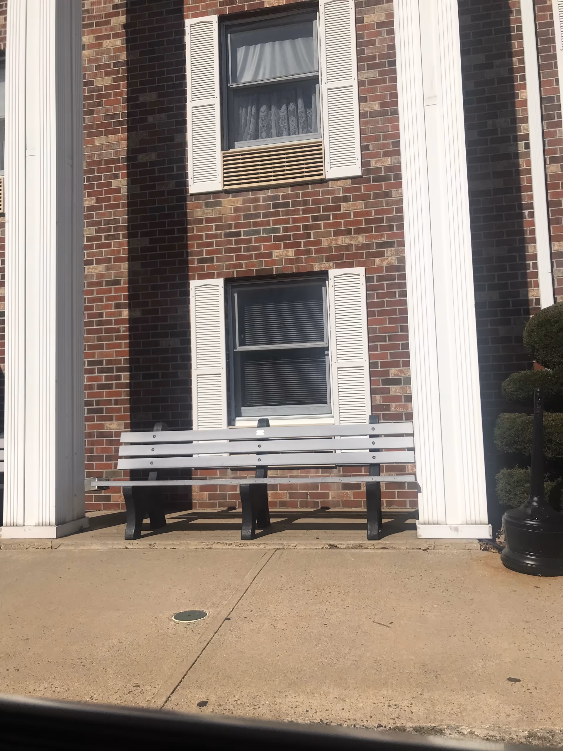 Gillette Manor exterior: brick facade with white columns and a bench outside.