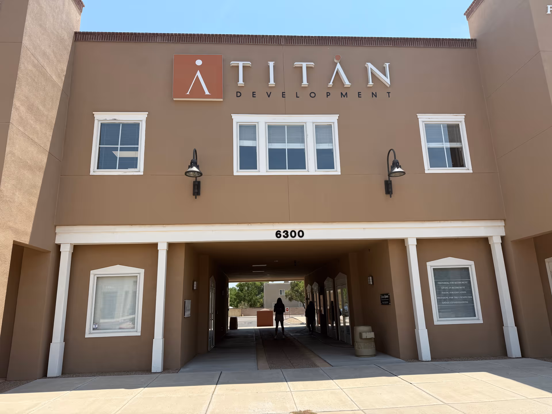Exterior view of a tan building with a covered entrance and two windows above.