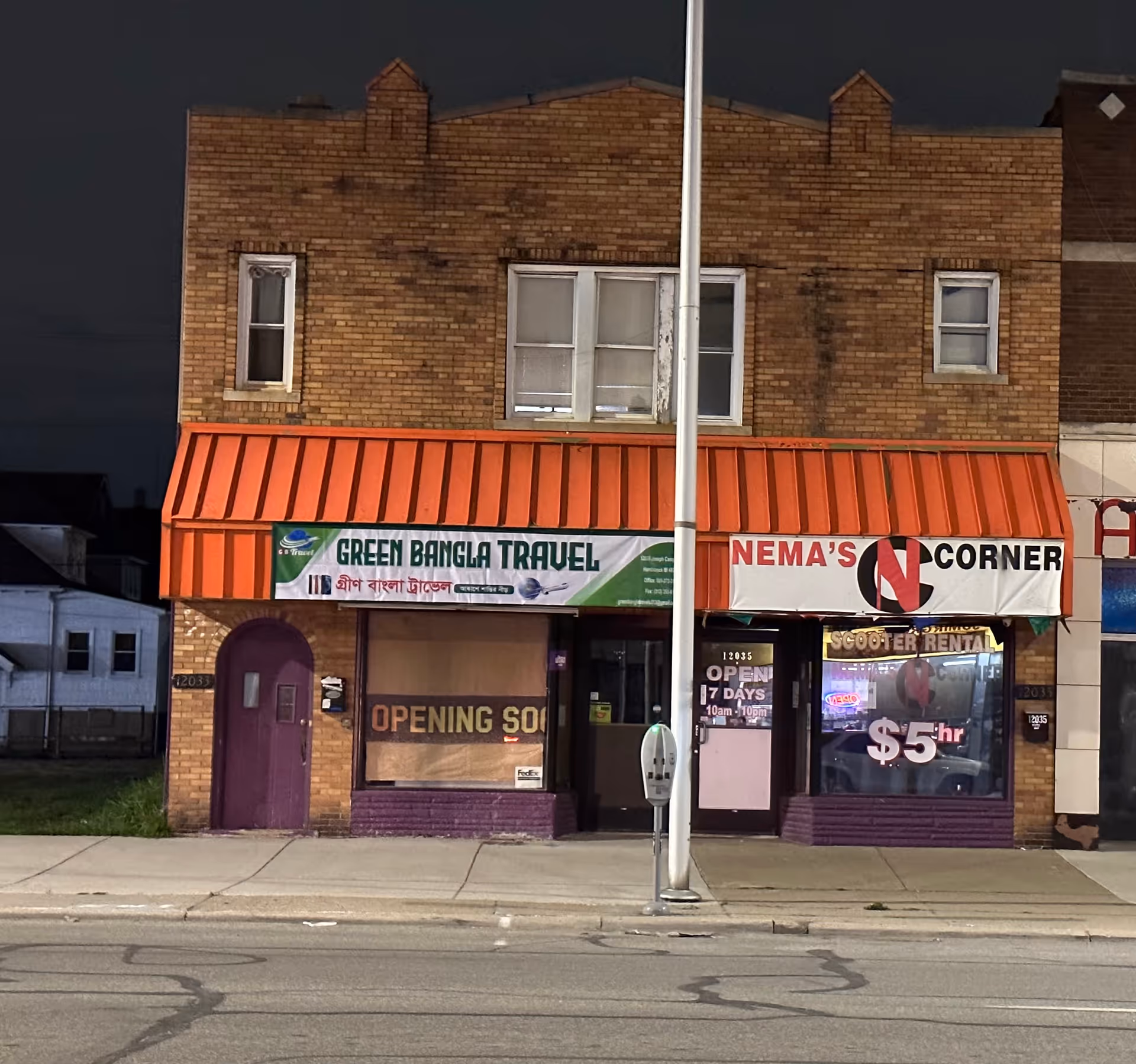 Brick storefront with travel agency signs and red awning along a city street