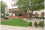 Exterior view of Berkley Manor Care Center with entrance, sign, and landscaping.