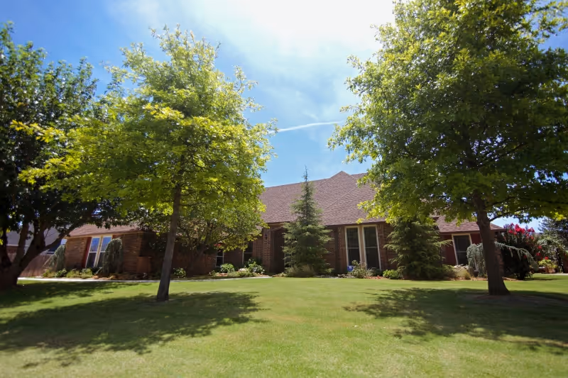 Exterior view of Right Choice Personal Assistance facility with brick walls, lawn, and trees.