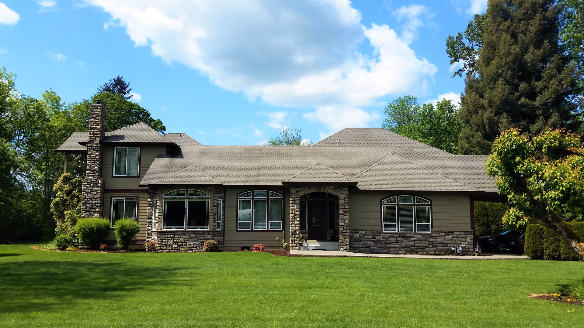 Front exterior of a large, ranch-style senior living home with a well-kept lawn.