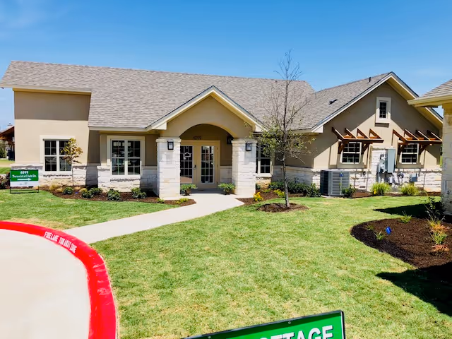 Single-story senior living facility with a landscaped lawn and central entry.