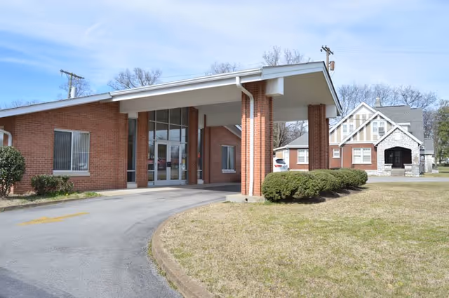 Exterior of Azalea Trace Assisted Living building with brick entrance and curved driveway.