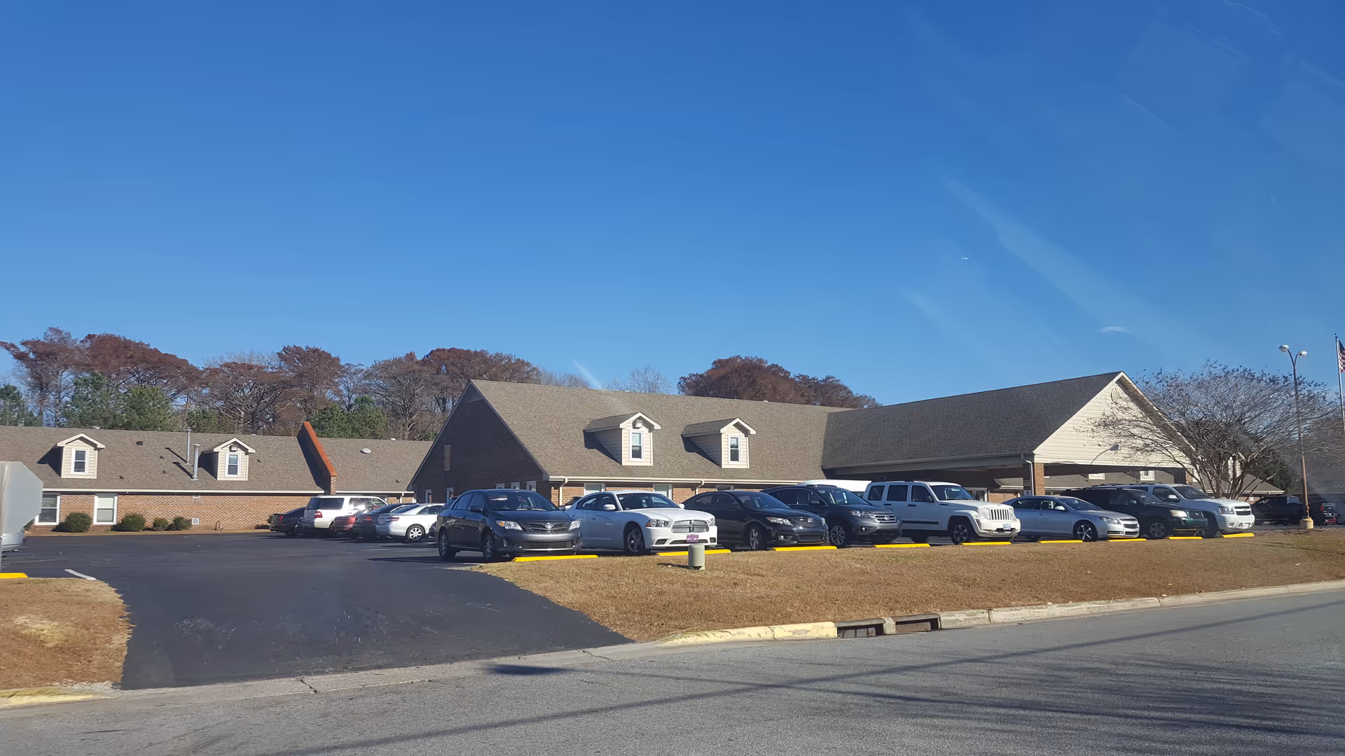 Exterior of River Trace Nursing and Rehabilitation Center with parked cars.