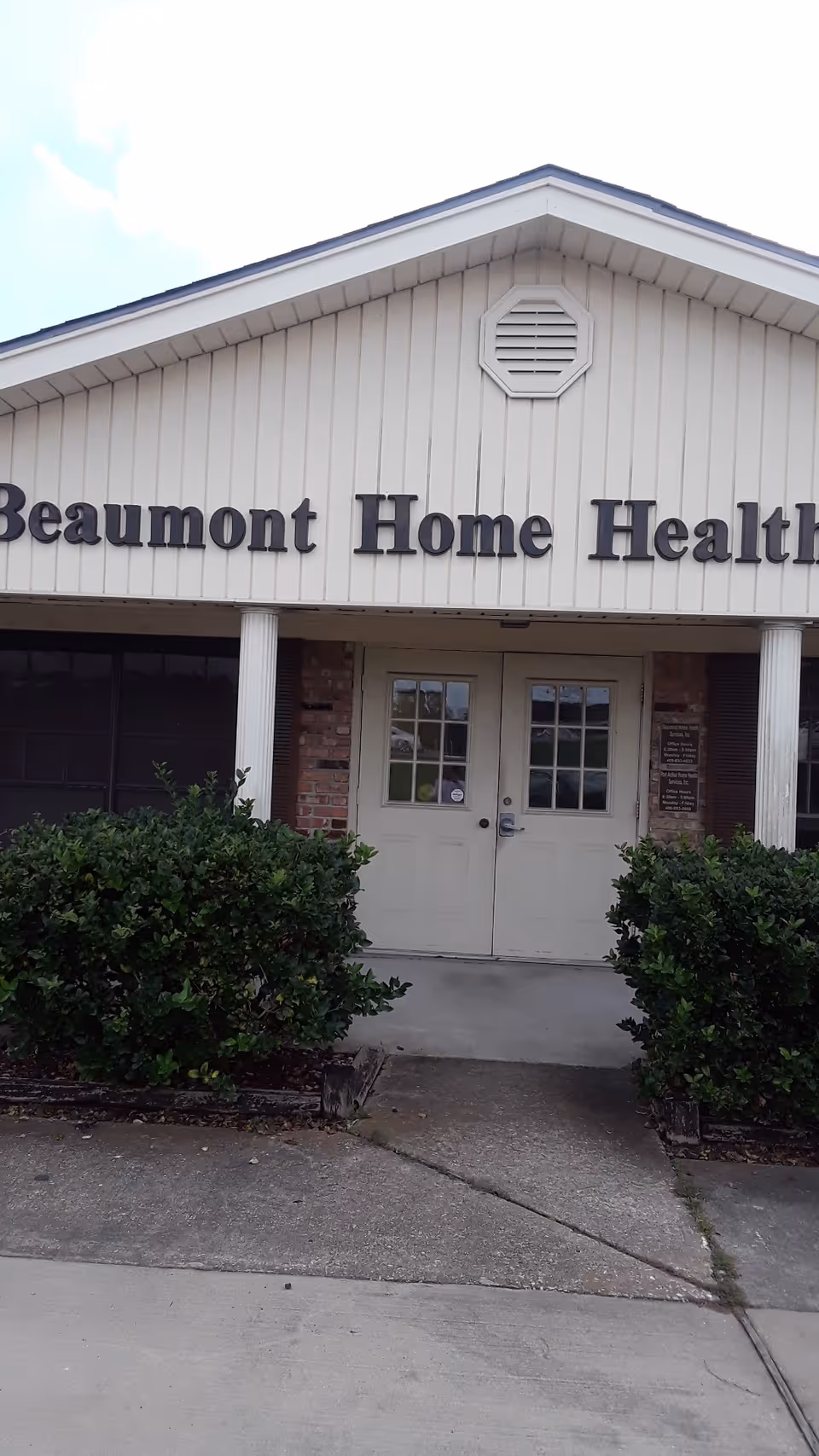 Exterior view of a beige building with double doors and Beaumont Home Health sign.
