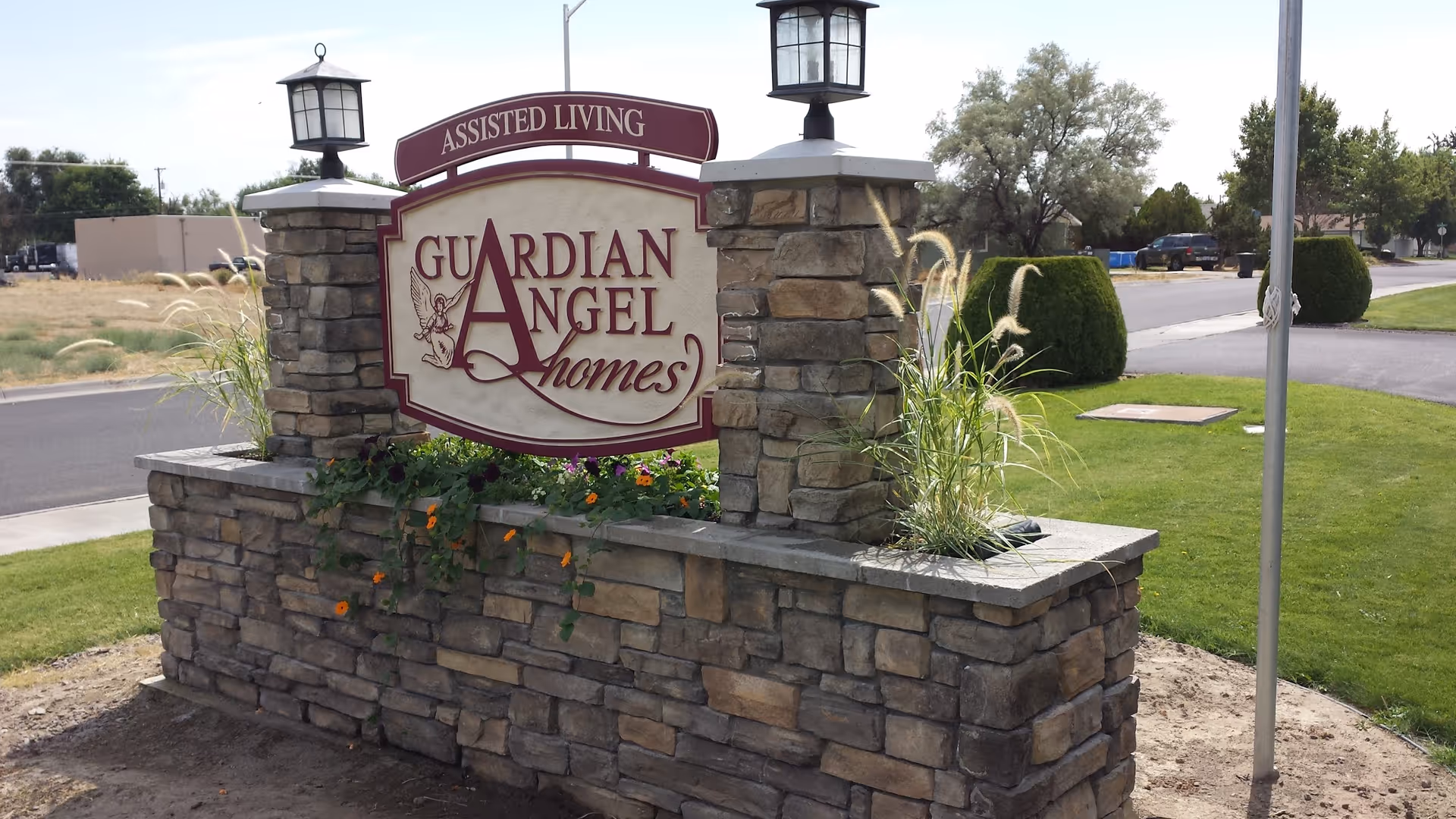 Stone front-entrance sign reads Guardian Angel Homes Assisted Living.