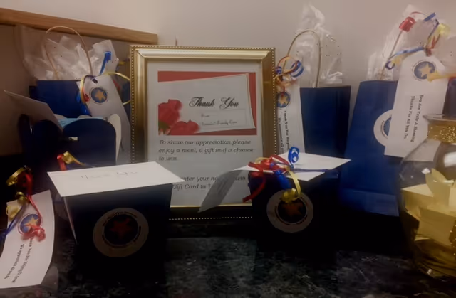 Indoor countertop displaying gift bags, tags, and a framed Thank You certificate.
