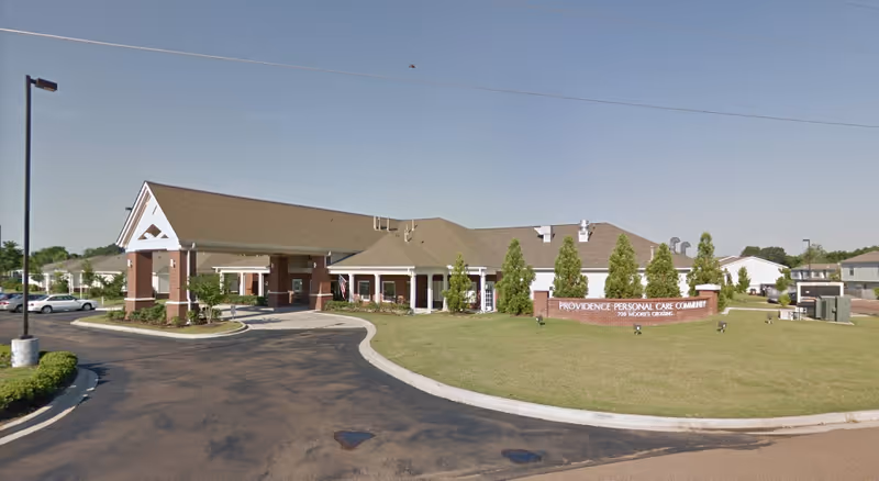 Exterior view of Providence Assisted Living facility with brick entrance and front sign.