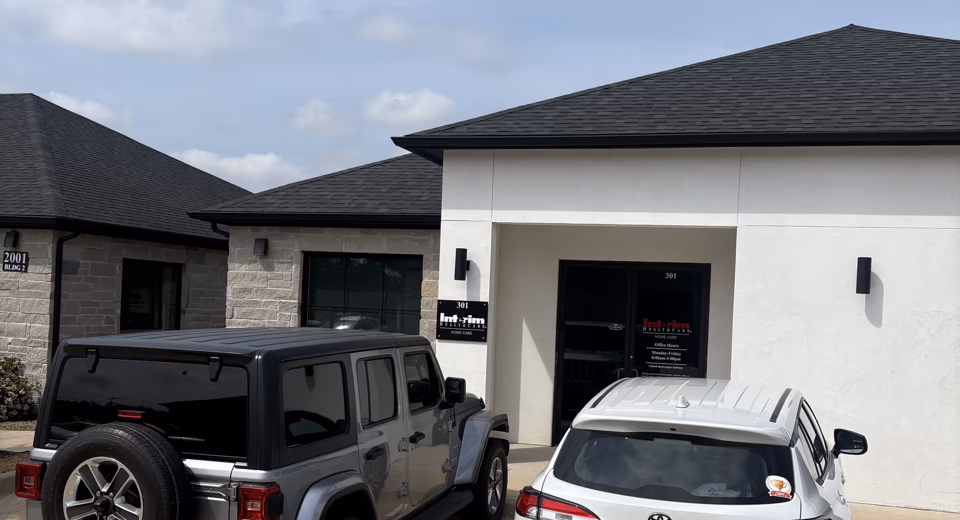 Exterior view of an Interim Home Healthcare facility entrance with parked cars in front