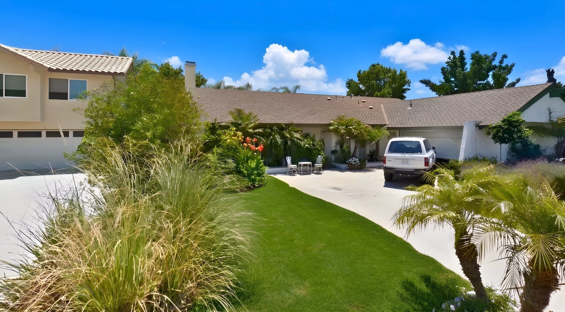 Sunshine Retirement Home Villa Park exterior with driveway, palm trees, and a parked SUV