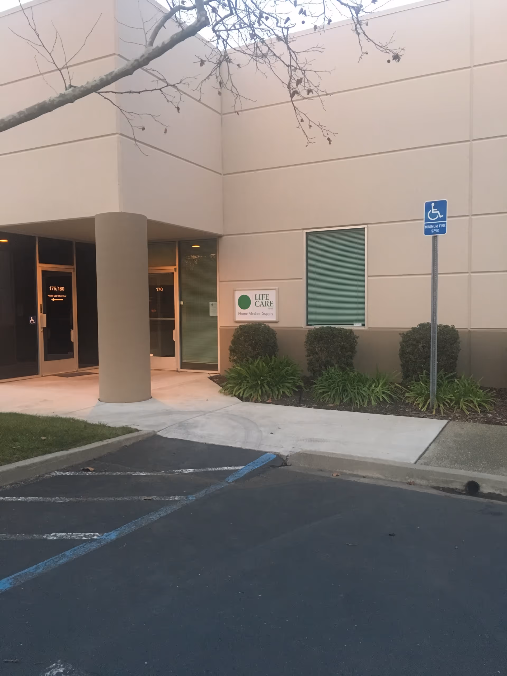Exterior of Life Care HME Medical Supply entrance with sign and parking.