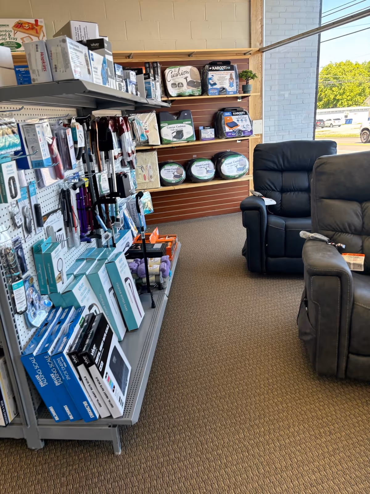 Interior showroom with shelves of medical supplies and two black leather recliner chairs.