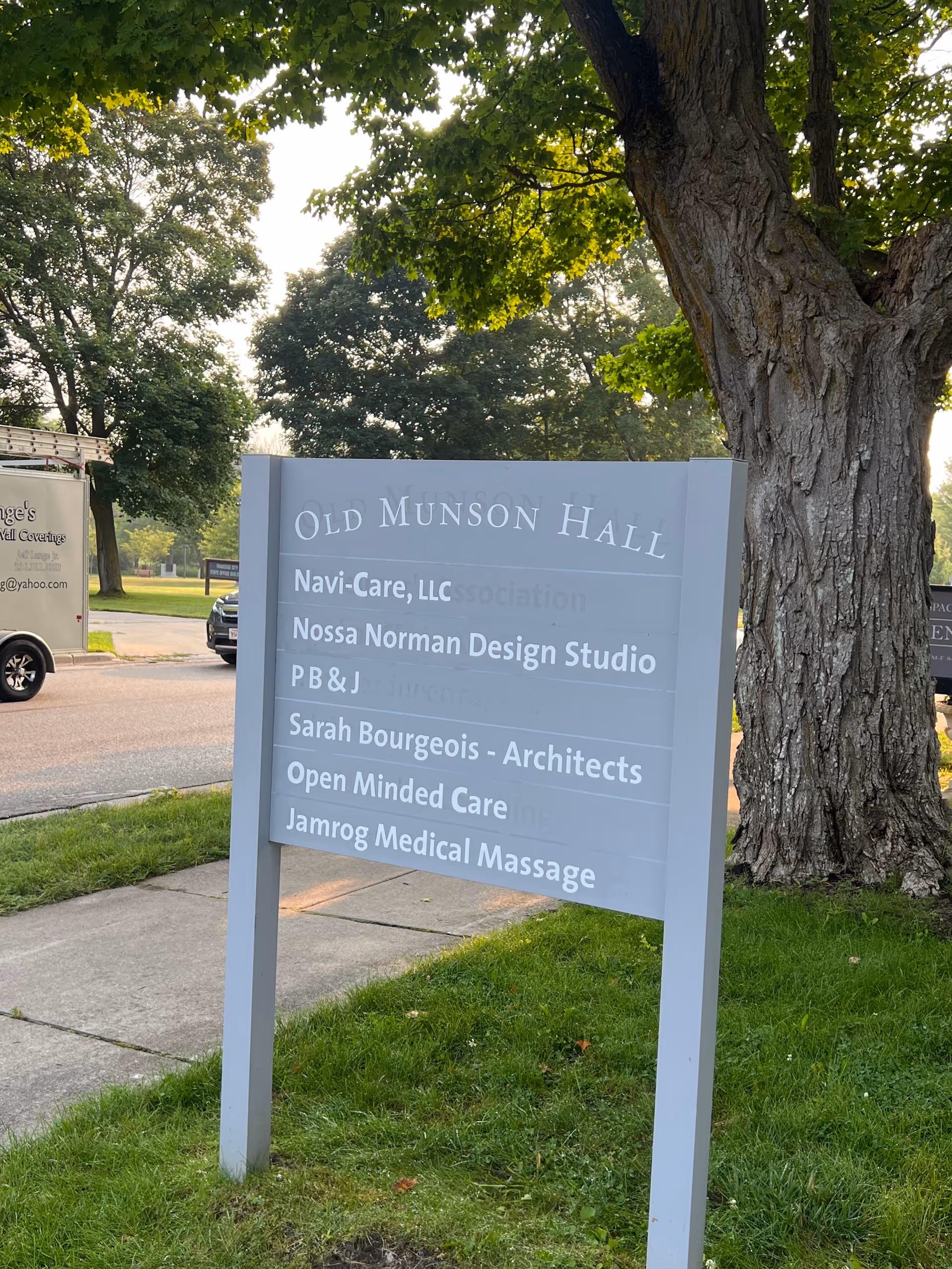 Outdoor sign lists Old Munson Hall tenants including Navi-Care and Open Minded Care.