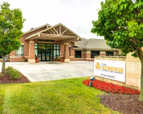 Exterior view of The Auberge at Oak Village entrance with a sign.